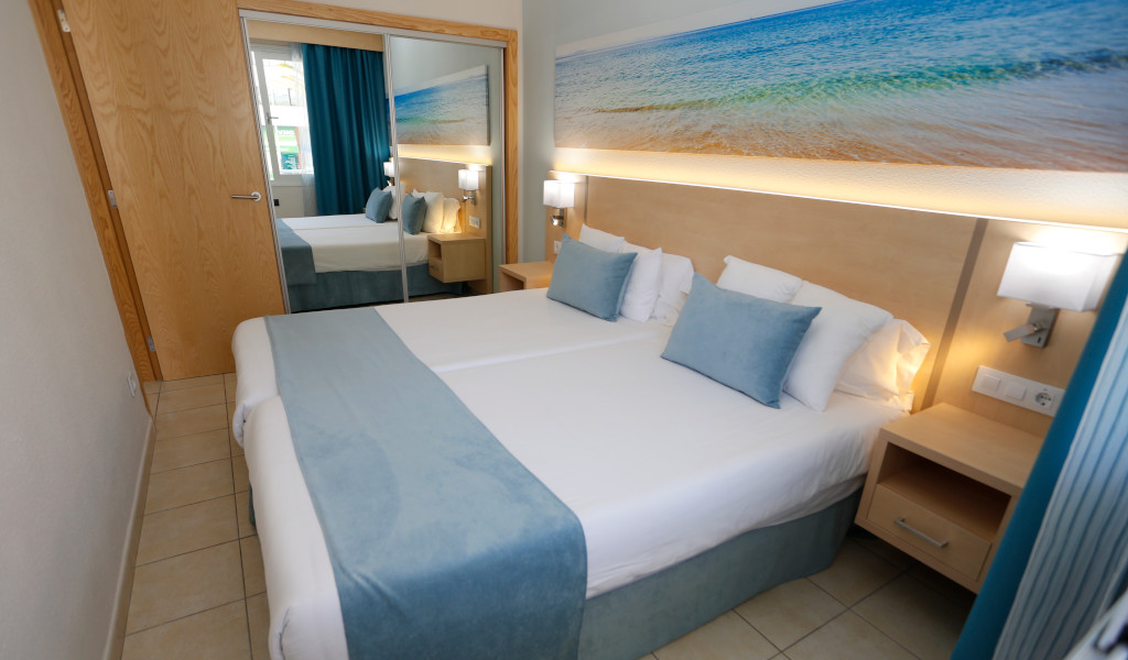 Tweepersoonskamer met tweepersoonsbed en stranddecoratie in een hotel op Tenerife.