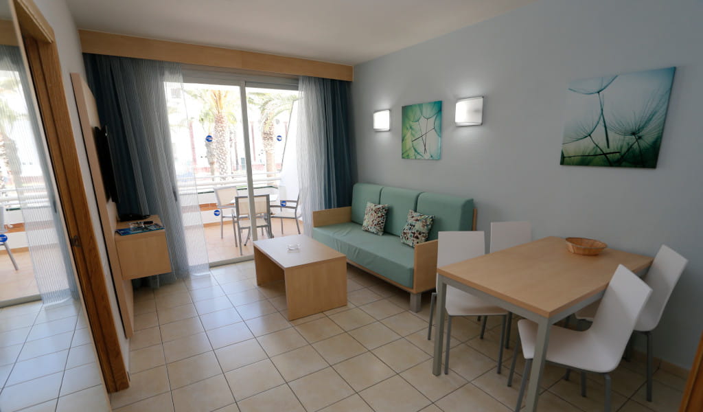 Woonkamer met bank, eettafel, balkon en decoratie in een appartement op Tenerife.