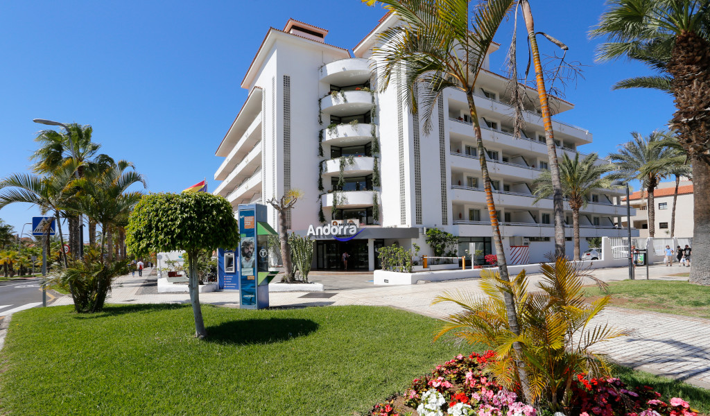 Het Andorra hotelgebouw omringd door palmbomen en bloemen op Tenerife.