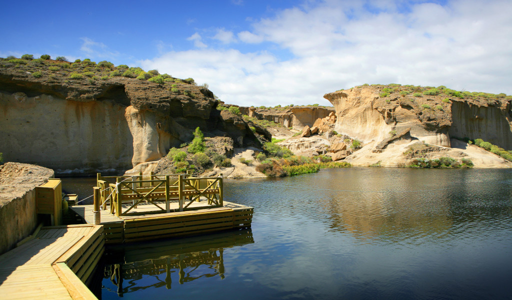 Houten pier voor rotsformaties en water op Tenerife.