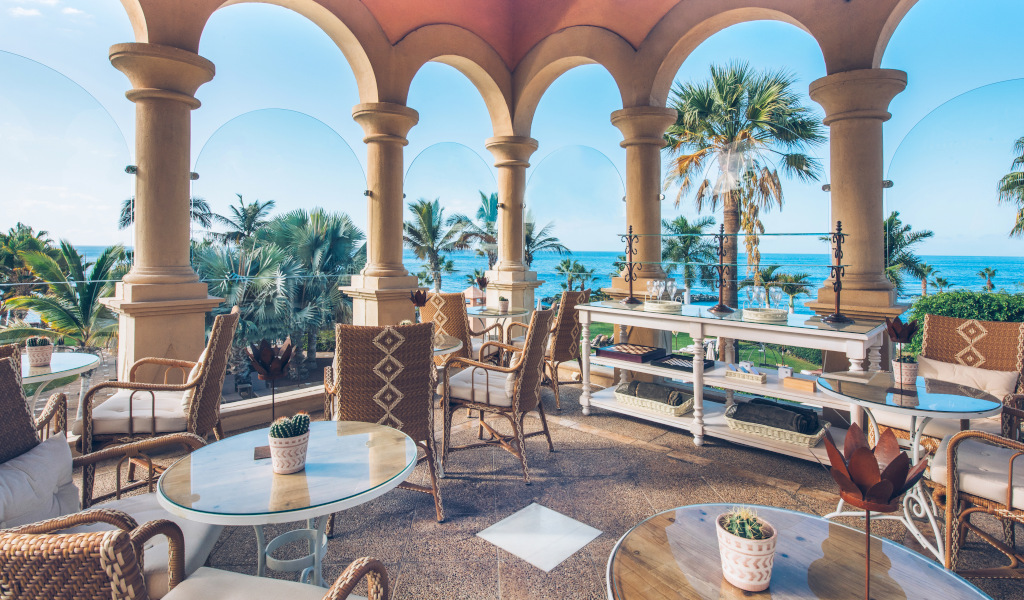 Terras met uitzicht op zee en palmbomen in een luxe hotel op Tenerife.