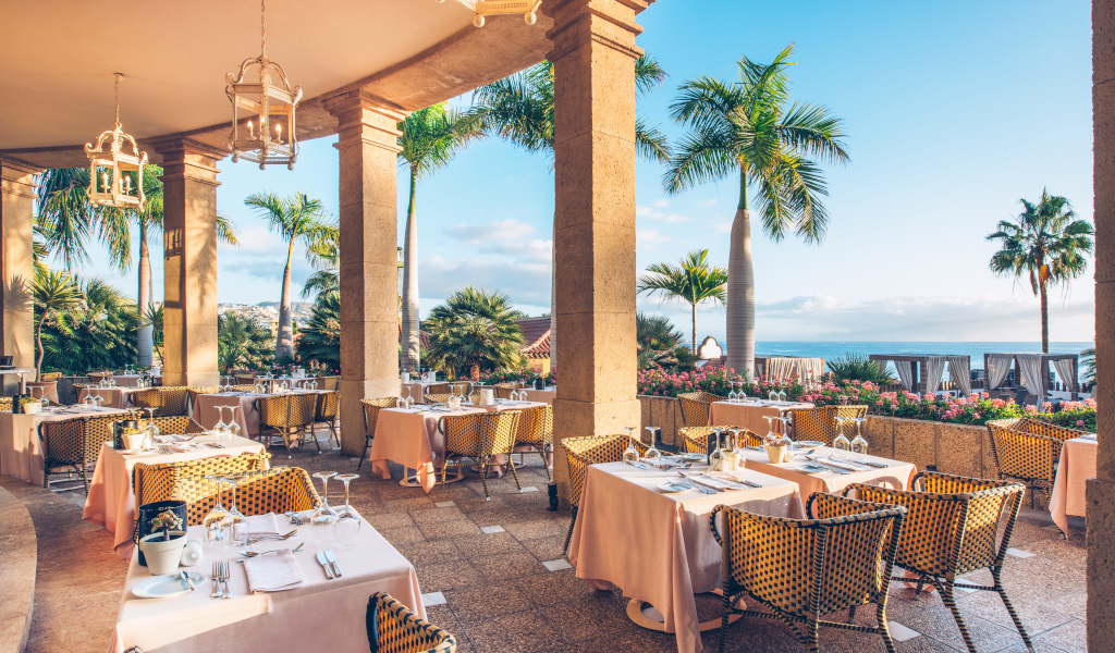 Openluchtrestaurant met tafels en palmbomen op Tenerife.