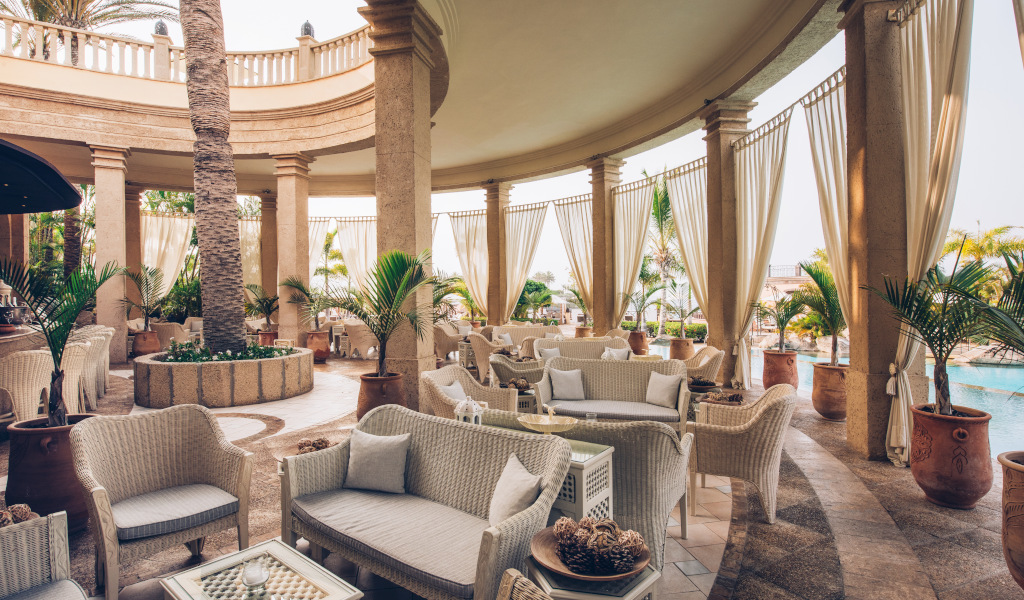 Terras met rotanmeubels en uitzicht op het zwembad op Tenerife.
