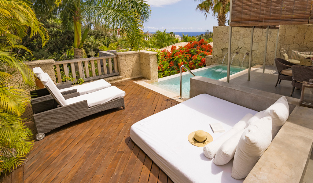 Terras op Tenerife met een klein zwembad, ligstoelen en tropische begroeiing.