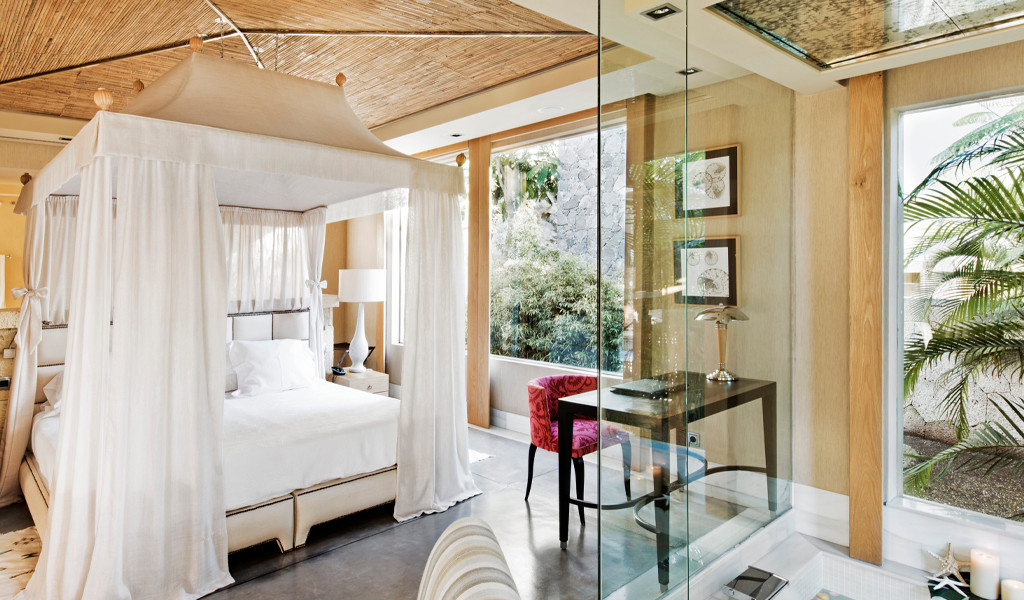 Kamer met hemelbed, bureau en raam met uitzicht op de tuin op Tenerife.