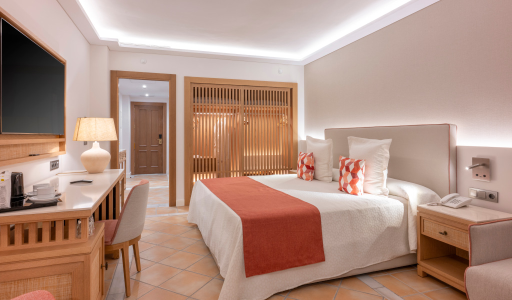 Hotelkamer op Tenerife met tweepersoonsbed, bureau en tv.