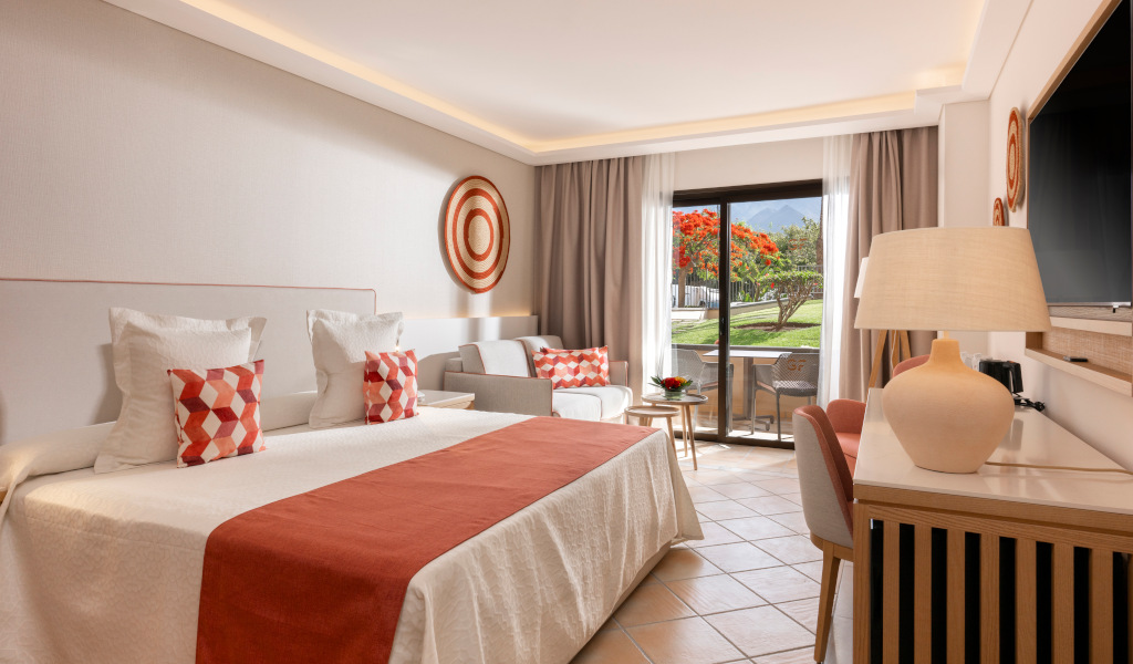 Hotelkamer op Tenerife met bed, balkon en uitzicht op de tuin.