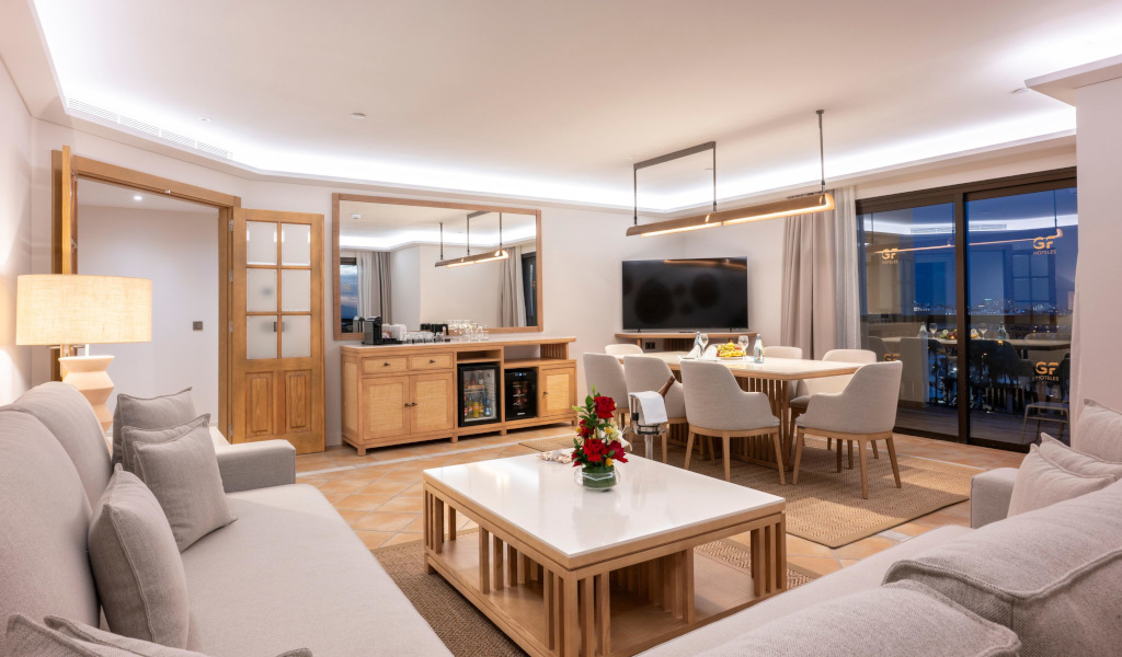 Elegante woonkamer met bank, salontafel, eettafel en tv in een appartement op Tenerife.