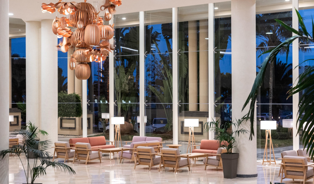 Woonkamer met fauteuils, lampen en een grote hanglamp in het hotel van Tenerife.