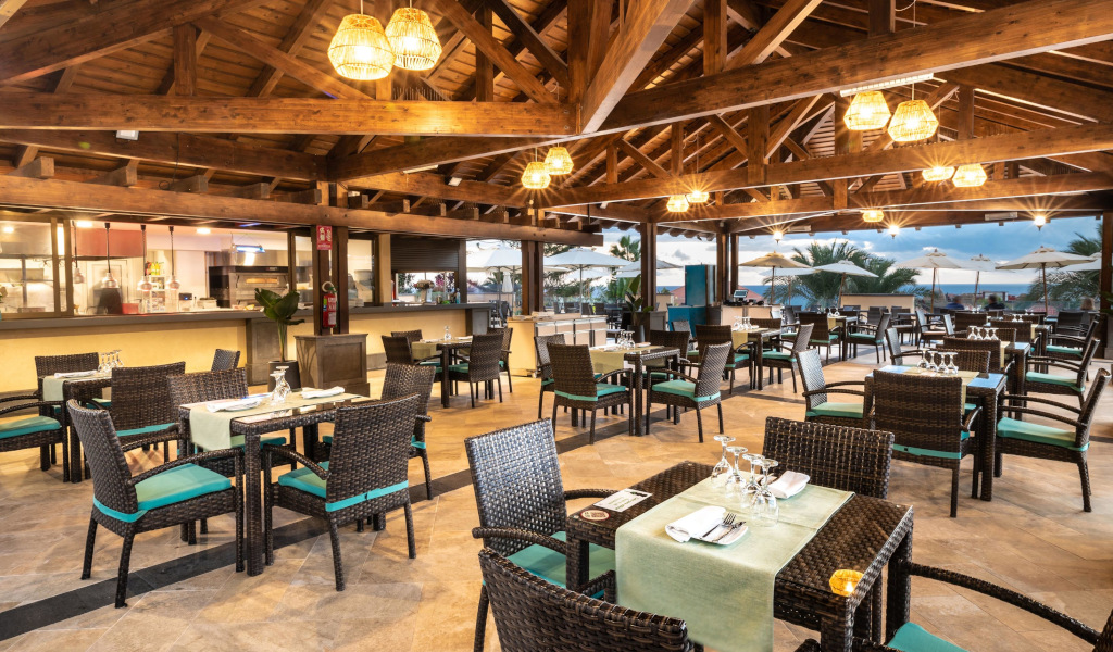 Openluchtrestaurant met tafels die op Tenerife zijn klaargemaakt, met uitzicht op het landschap bij zonsondergang.
