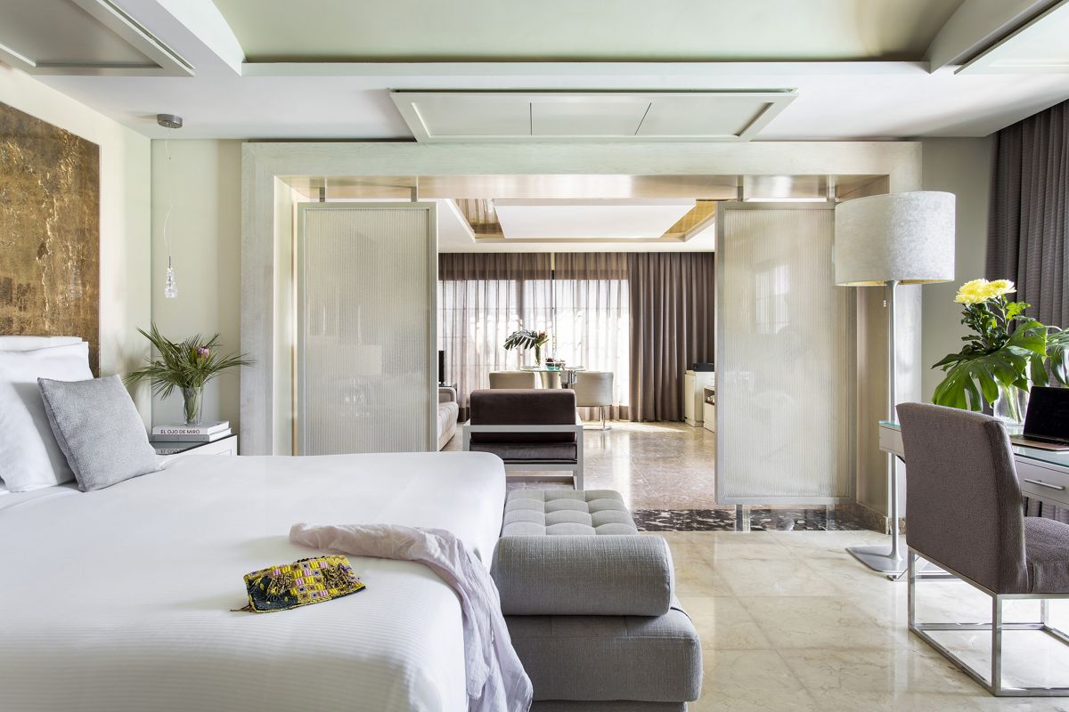 Hotelkamer op Tenerife met bed, bureau, bank en gesloten gordijnen.