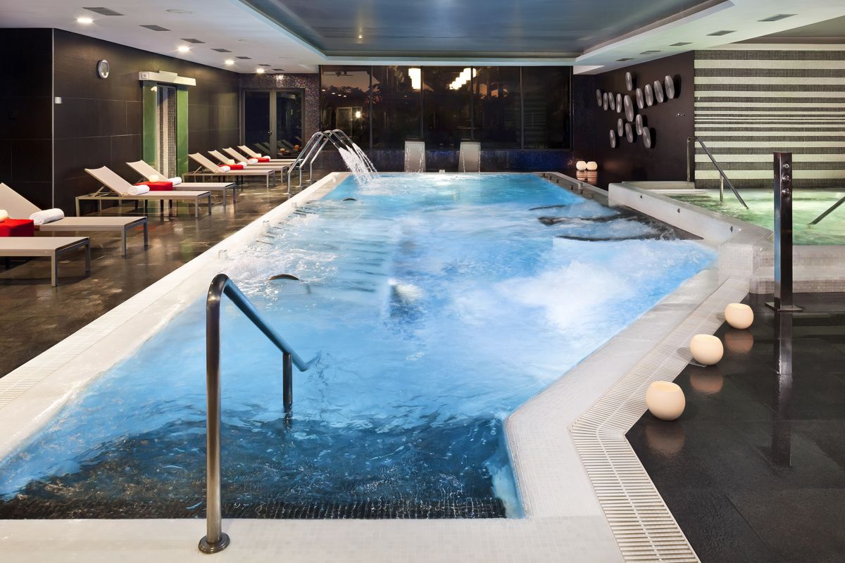 Binnenzwembad met ligstoelen en jacuzzi in een spa op Tenerife.