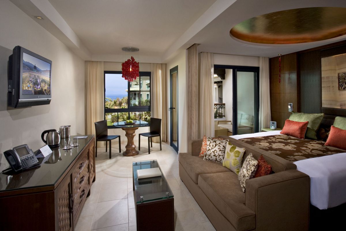 Hotelkamer op Tenerife met bed, bank en tafel bij het raam.