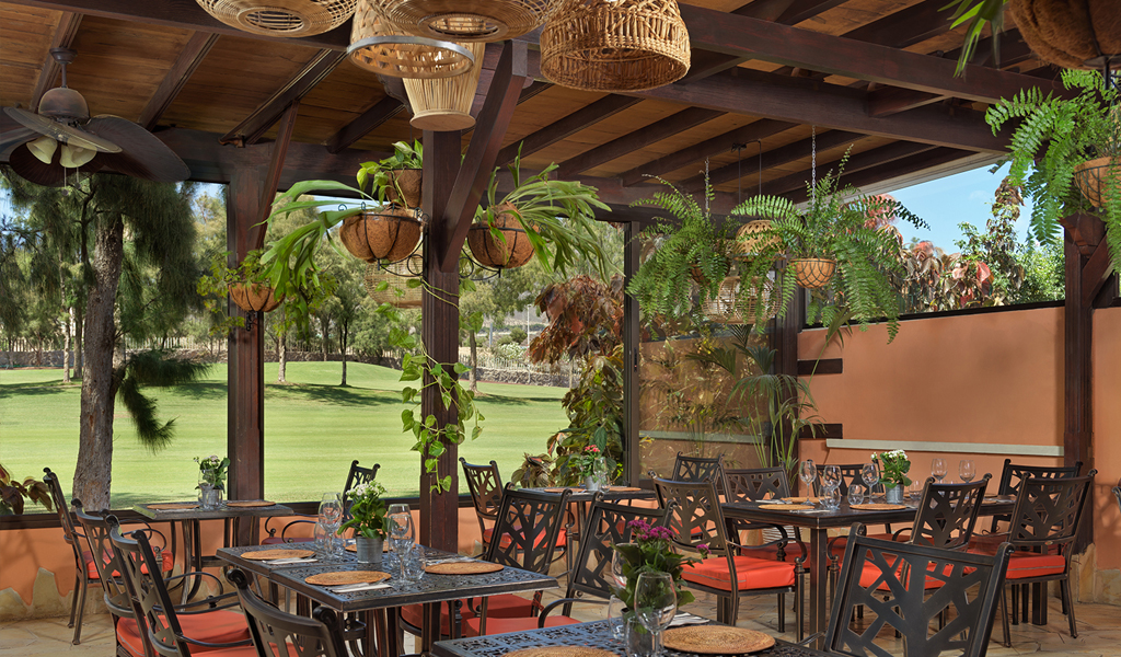 Restaurantterras met tafels en stoelen op een golfbaan op Tenerife.