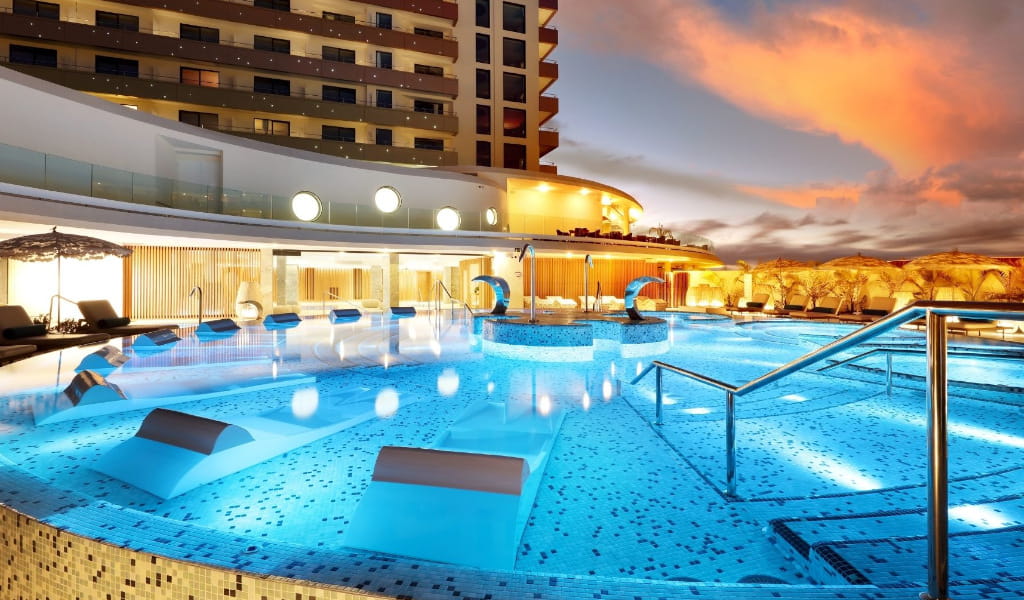 Verlicht zwembad in het hotel op Tenerife bij zonsondergang.