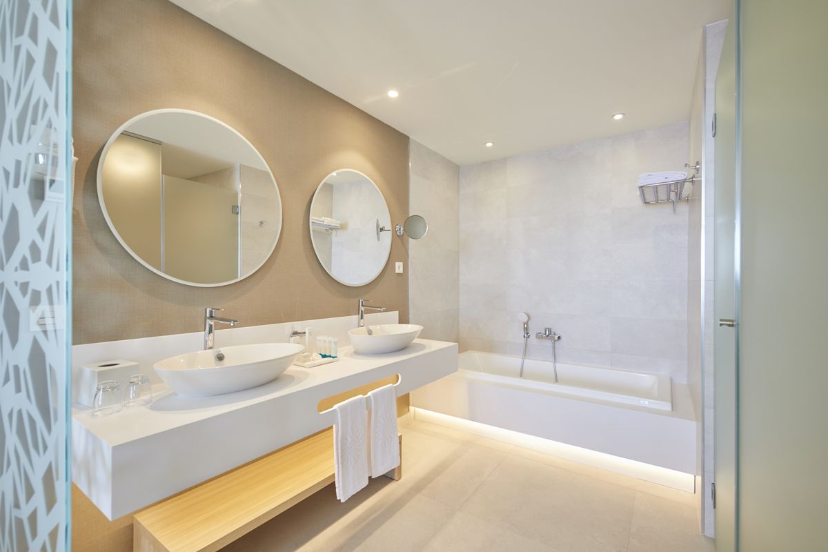Moderne badkamer met twee wastafels, twee ronde spiegels en bad op Tenerife.