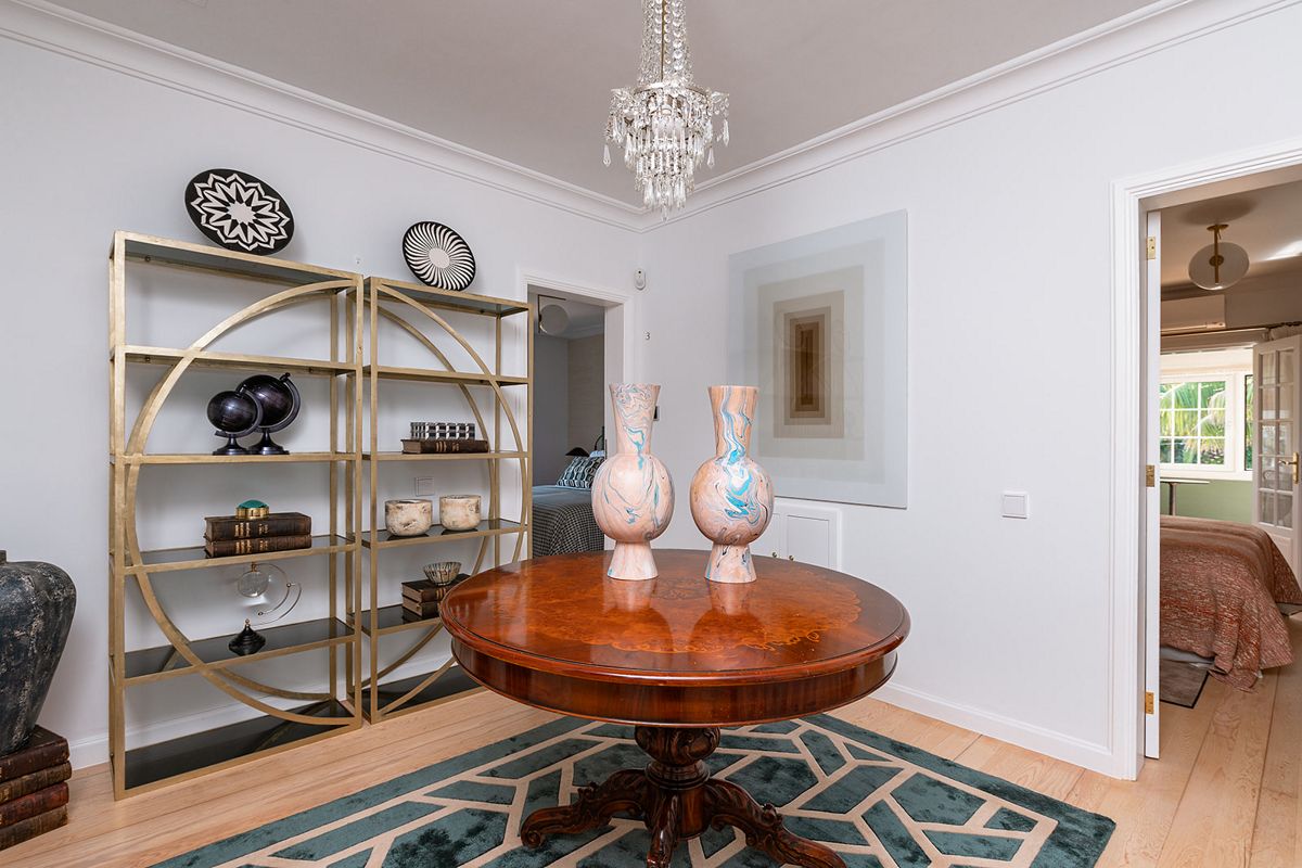 Kamer op Tenerife met ronde tafel, gouden plank en ornamenten.