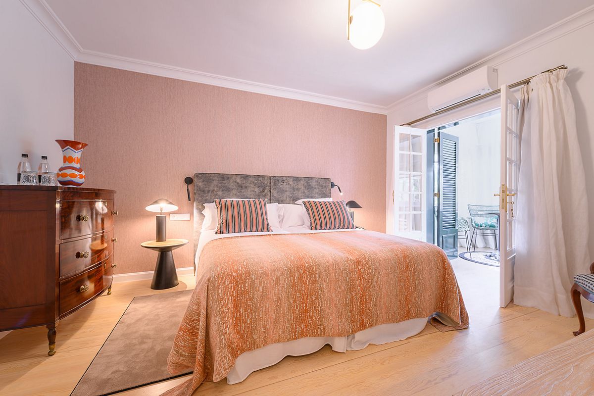 Een lichte kamer met een groot bed en toegang tot een terras op Tenerife.