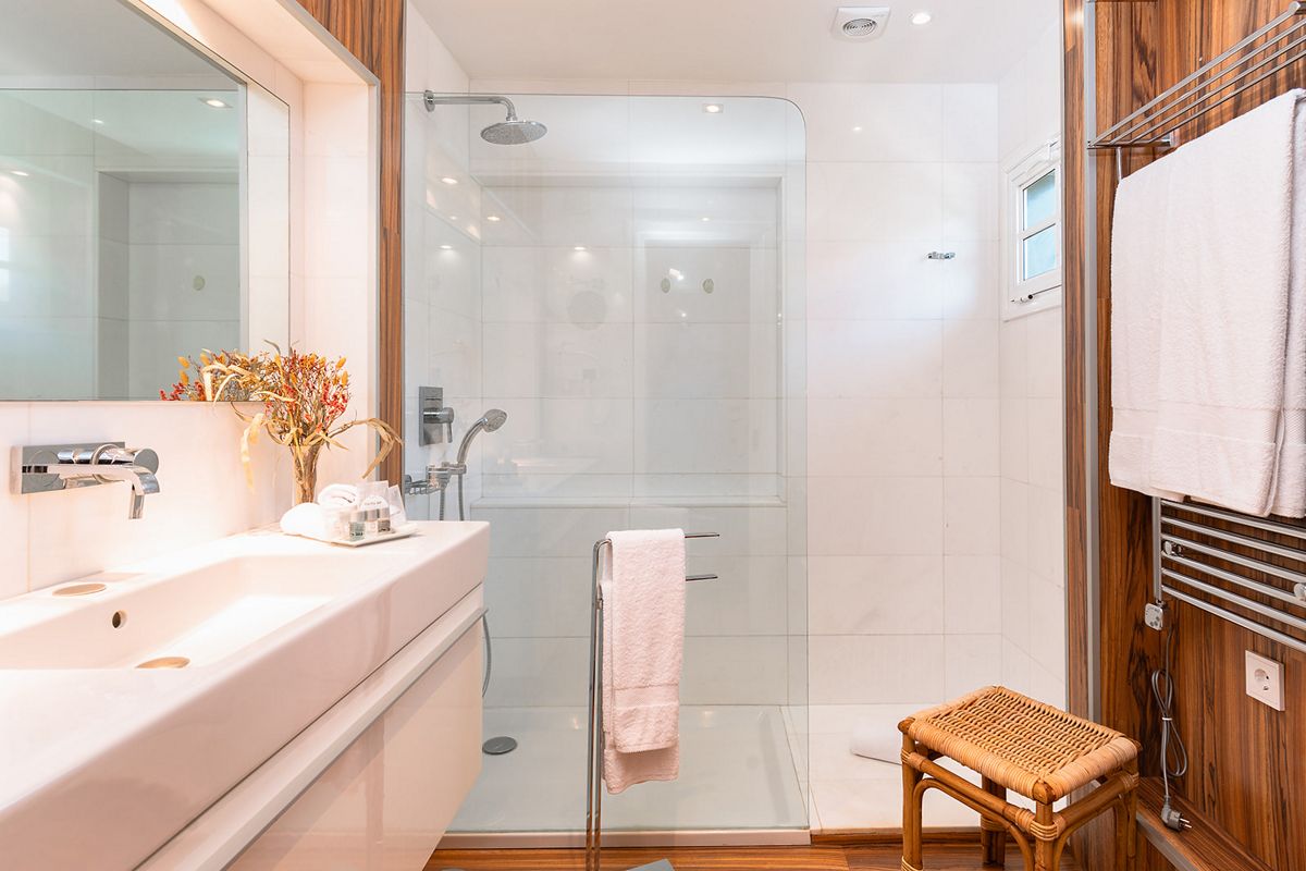 Moderne badkamer met douche, witte wastafel en handdoeken in een hotel op Tenerife.