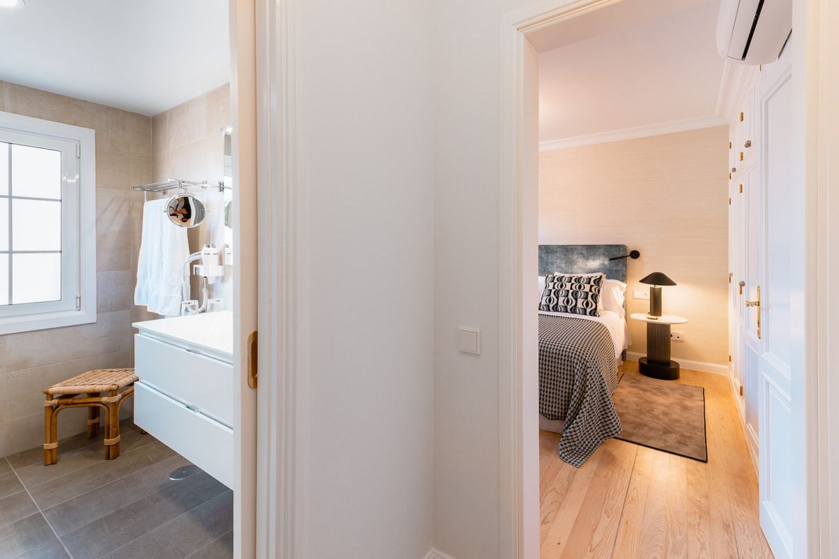 Badkamer met raam, wastafel en handdoeken, en slaapkamer met bed en lamp op Tenerife.
