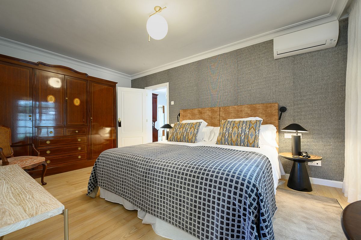 Kamer met tweepersoonsbed, houten kledingkast en tafellamp op Tenerife.
