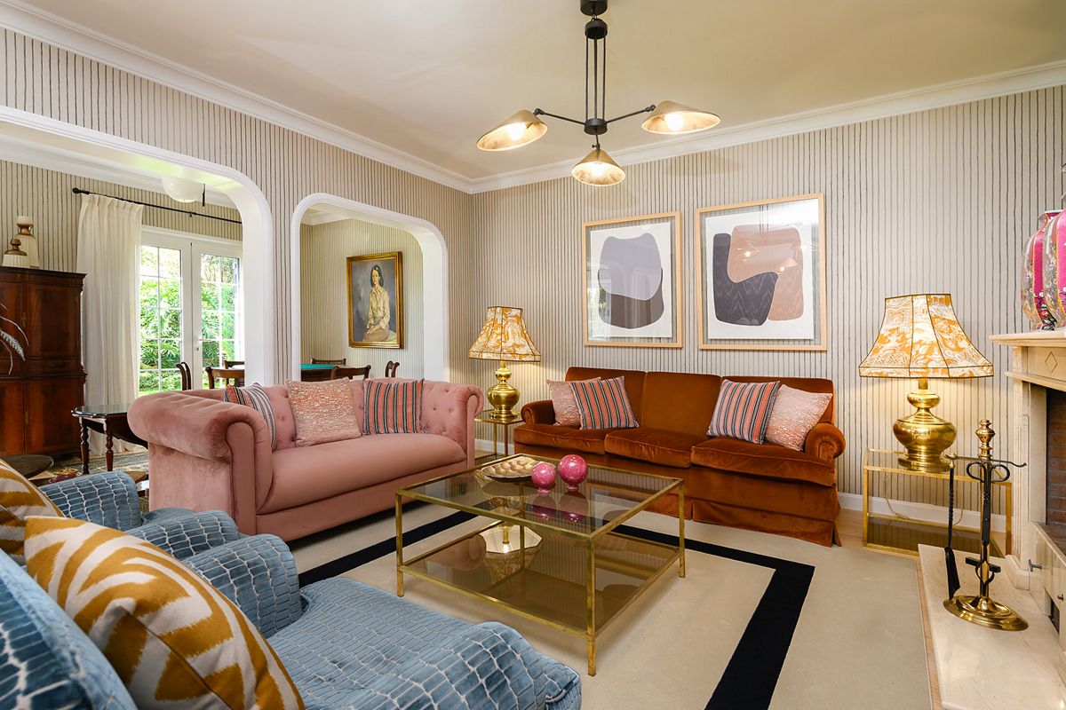 Woonkamer met banken, glazen tafel en schilderijen hangend in een huis op Tenerife.