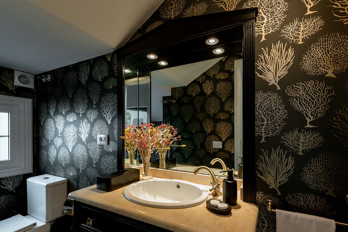Elegante badkamer met wastafel, grote spiegel en koraalbehang op Tenerife.