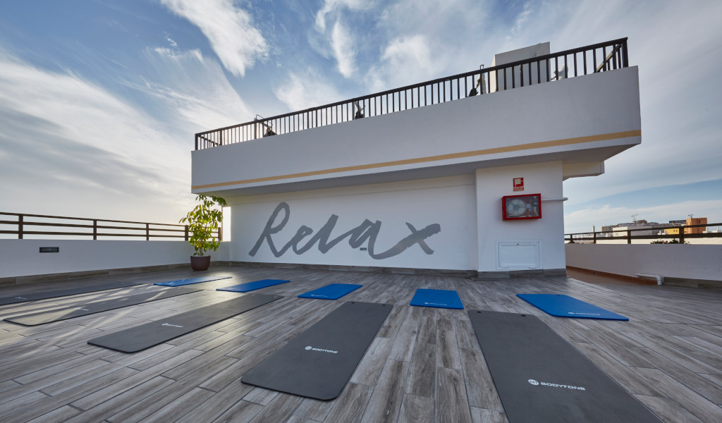 Dakterras met yogamatten en het woord Relax on the wall in Tenerife.