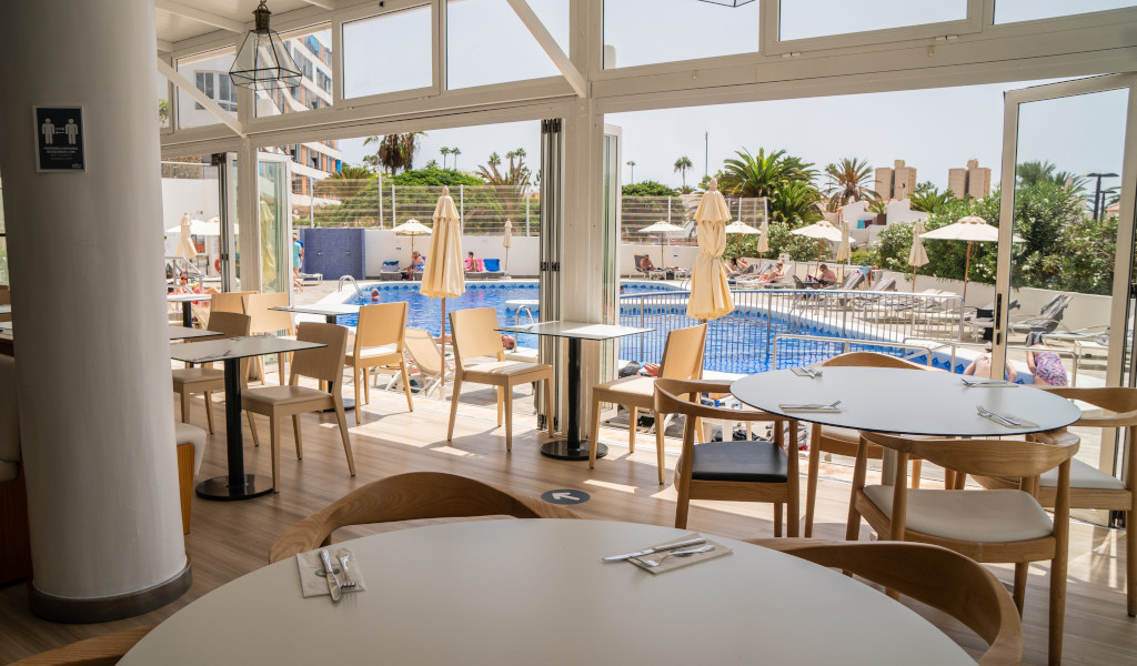 Uitzicht vanuit het restaurant richting het zwembad en terras op Tenerife.
