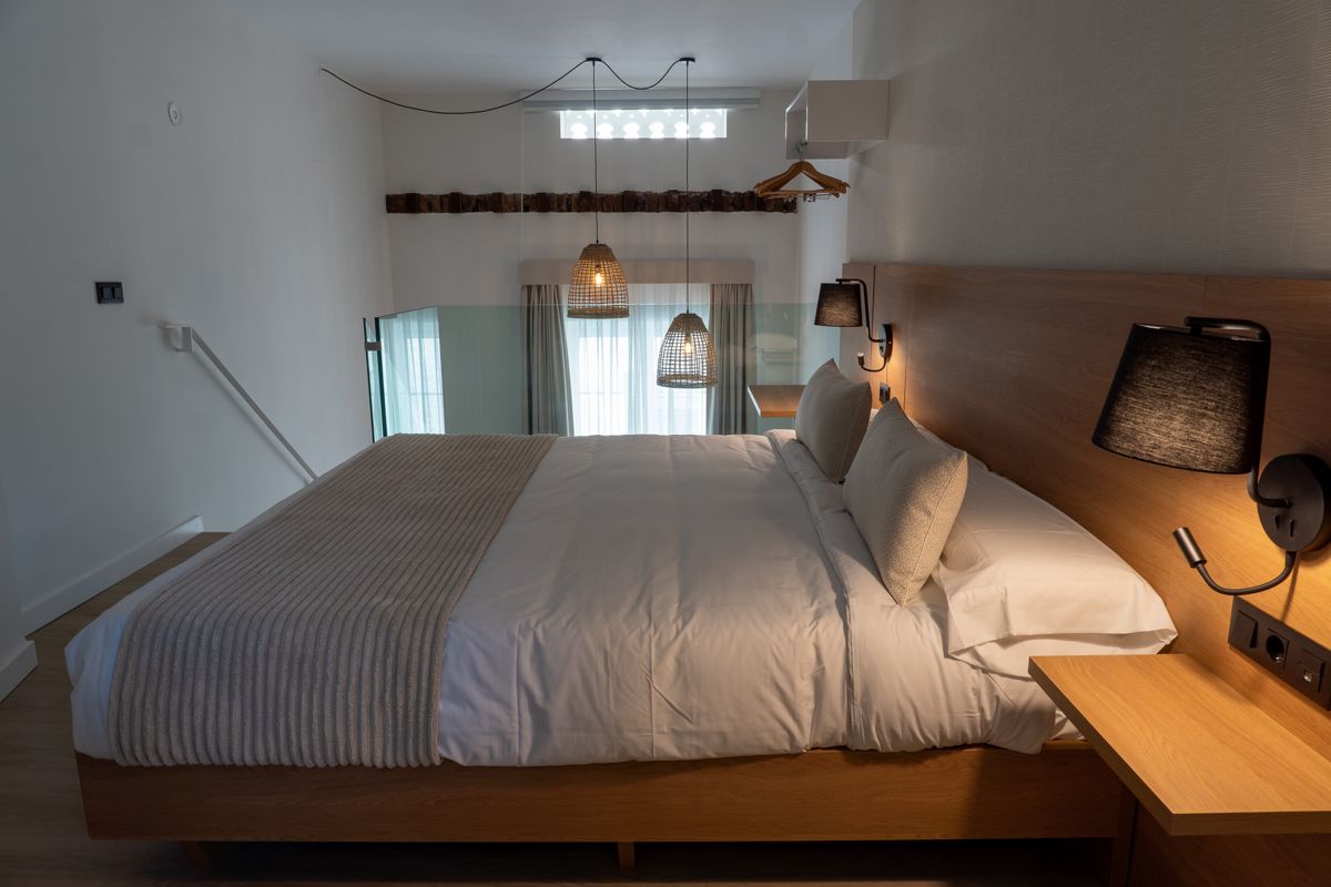 Tweepersoonsbed in een moderne kamer op Tenerife. Decoratie in neutrale tinten.
