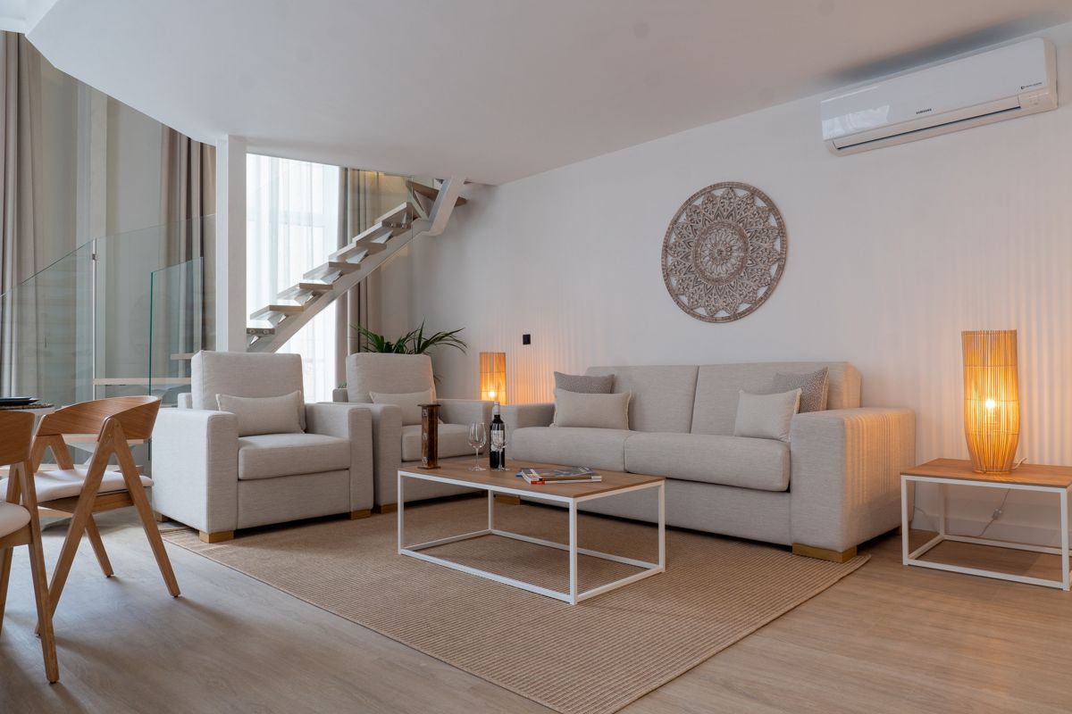 Moderne woonkamer met beige banken en trap op Tenerife.