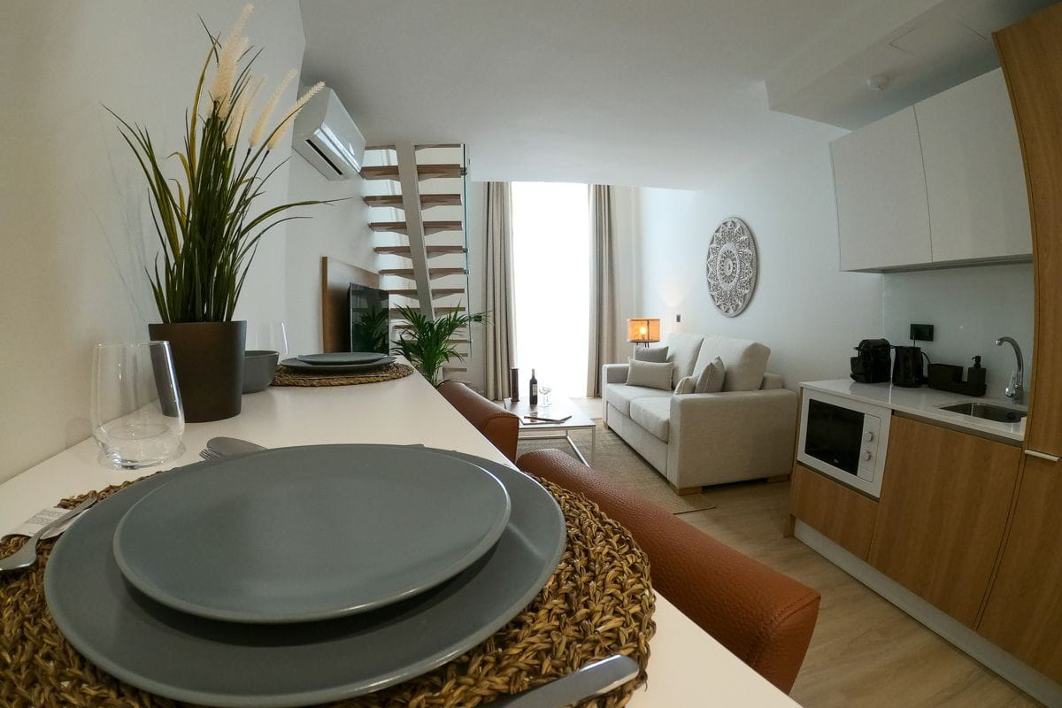 Moderne woonkamer met bank en keuken, geïntegreerd in het appartement van Tenerife.