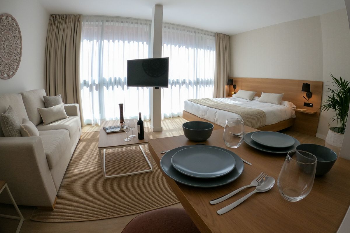 Kamer op Tenerife met bed, bank en eettafel voor twee personen.