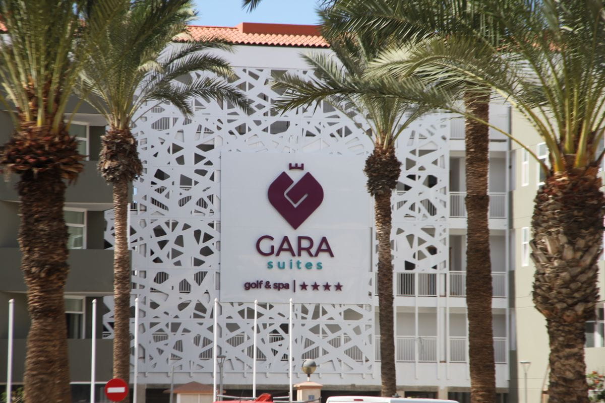 Gara Suites Golf & Spa op Tenerife met een decoratieve gevel en palmbomen ervoor.