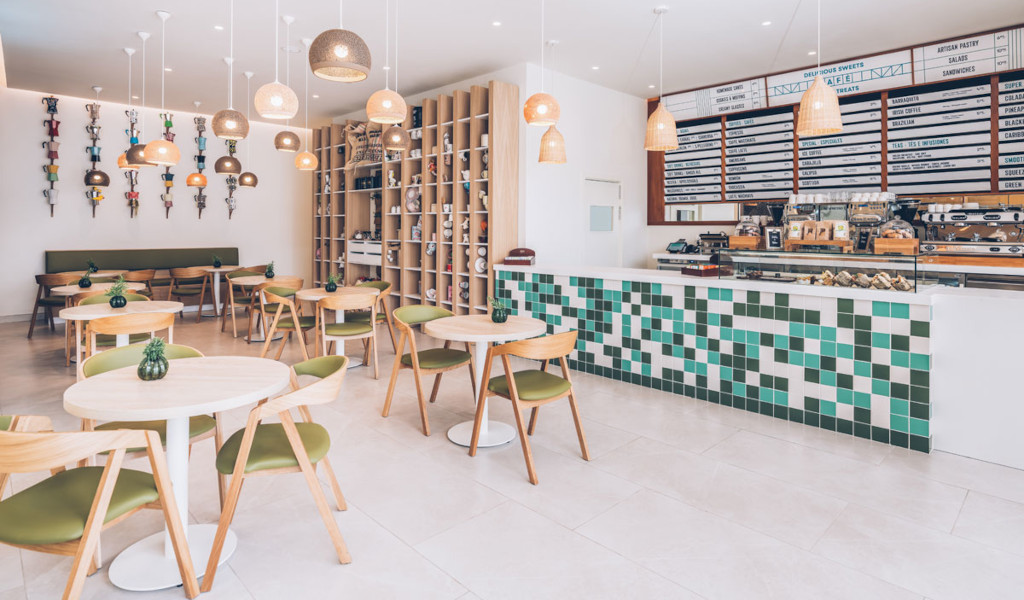 Modern café op Tenerife met houten stoelen en een met groen betegelde toonbank.