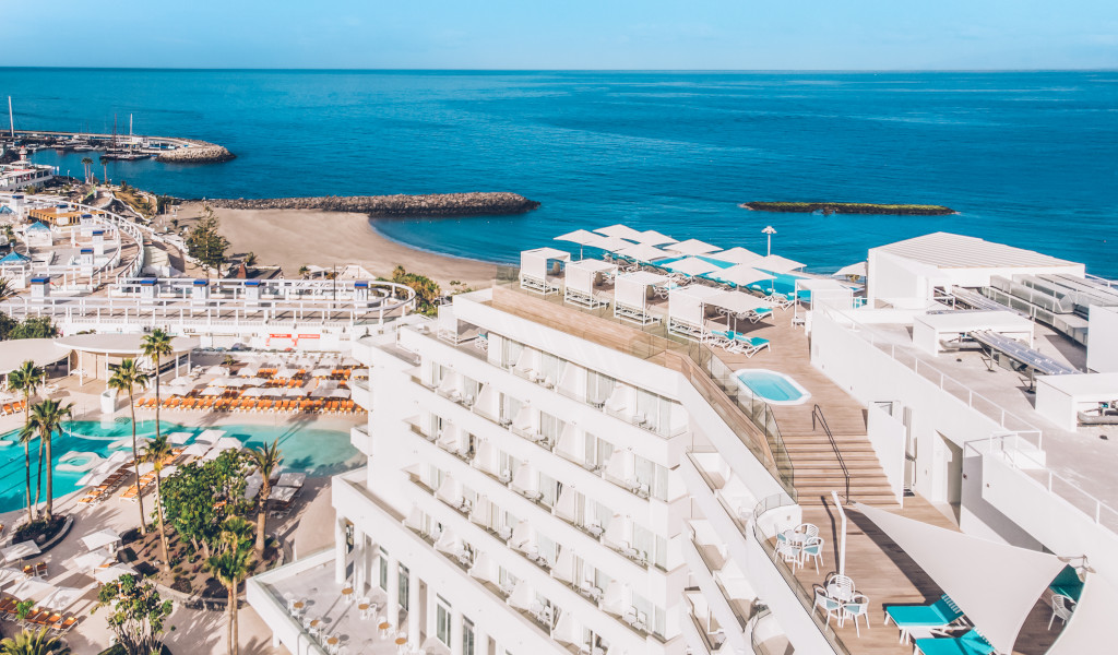 Luchtfoto van het hotel en strand op Tenerife met zwembaden en blauwe zee op de achtergrond.