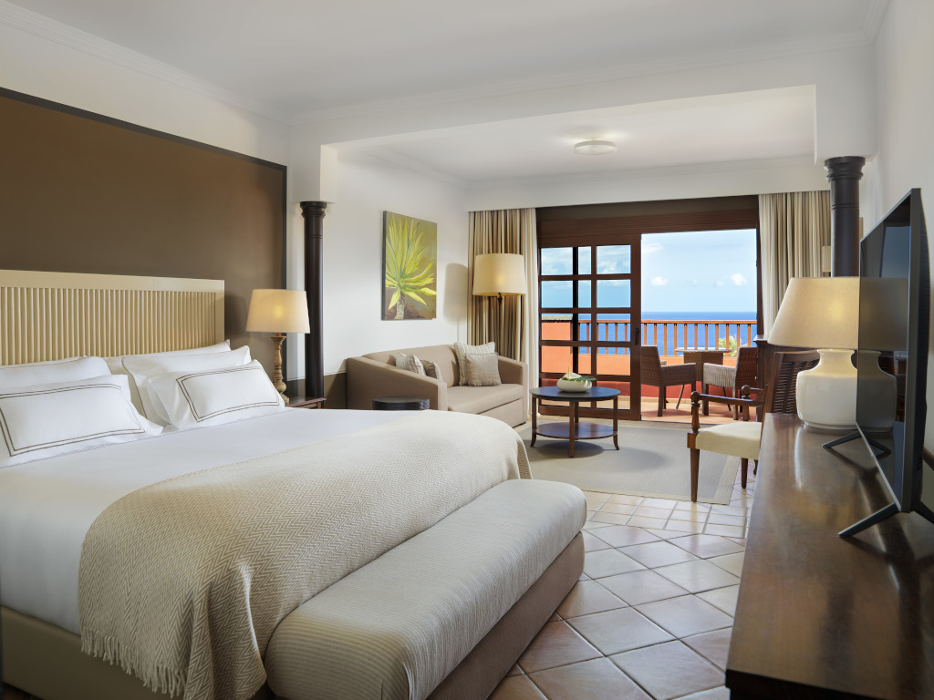 Hotelkamer op Tenerife met een groot bed en uitzicht op de tuin.