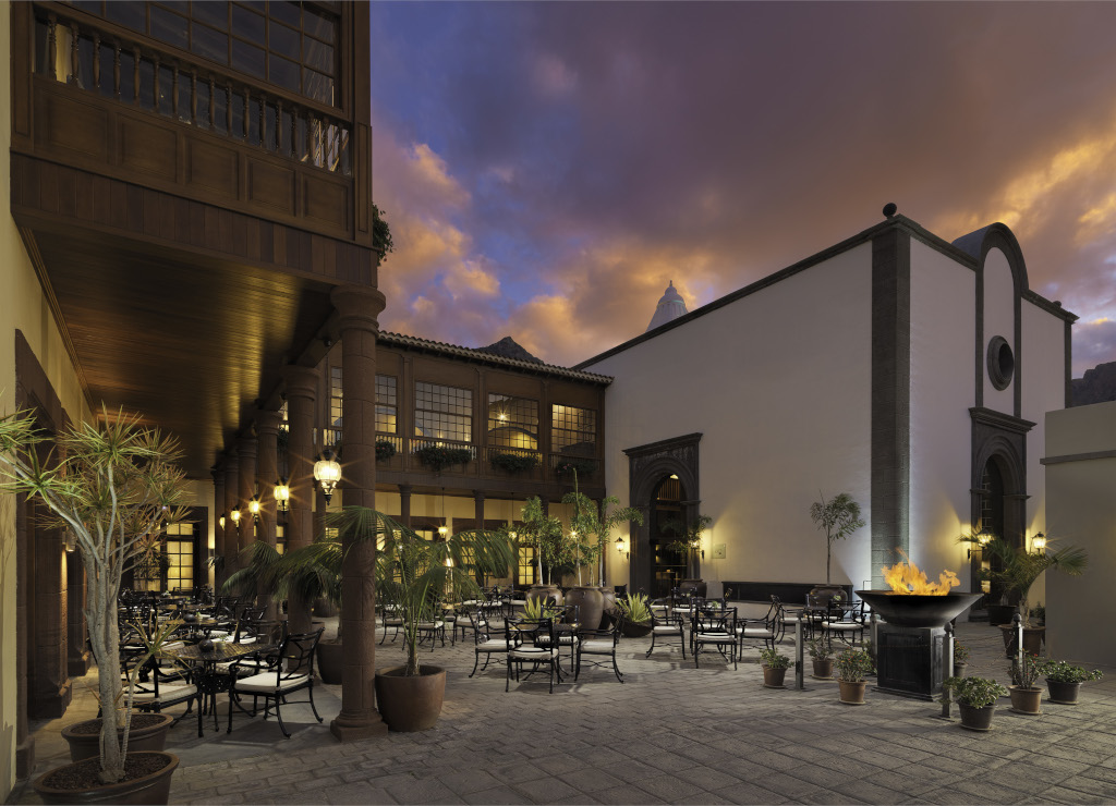 Buitenterras op Tenerife bij zonsondergang met tafels en planten.
