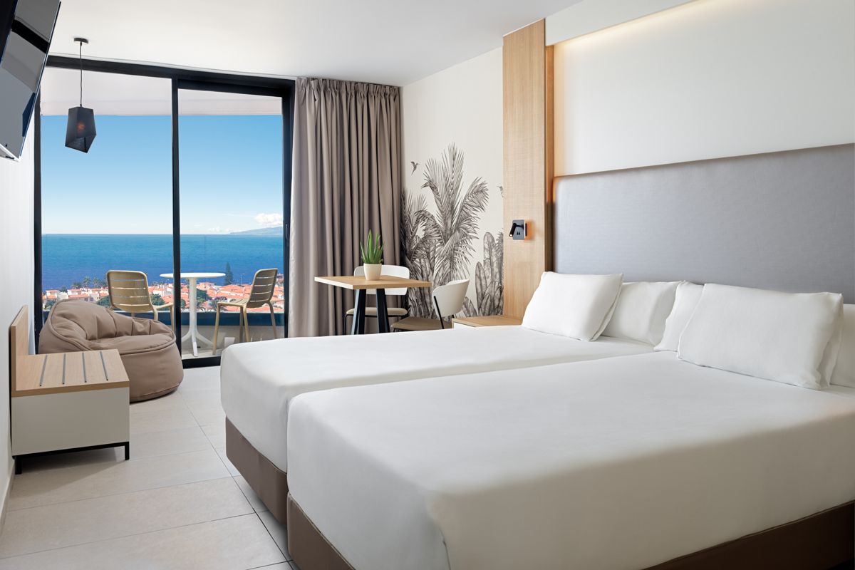 Moderne kamer met tweepersoonsbedden en zeezicht op Tenerife.