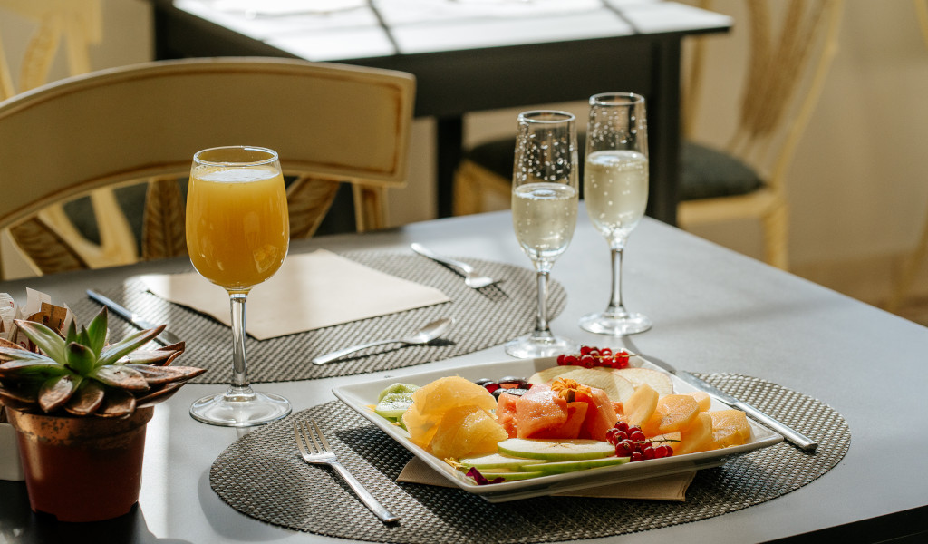 Ontbijt met fruit, sinaasappelsap en glazen champagne aan tafel op Tenerife.