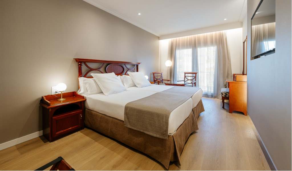 Dubbele kamer in een hotel op Tenerife met bed en houten meubels.