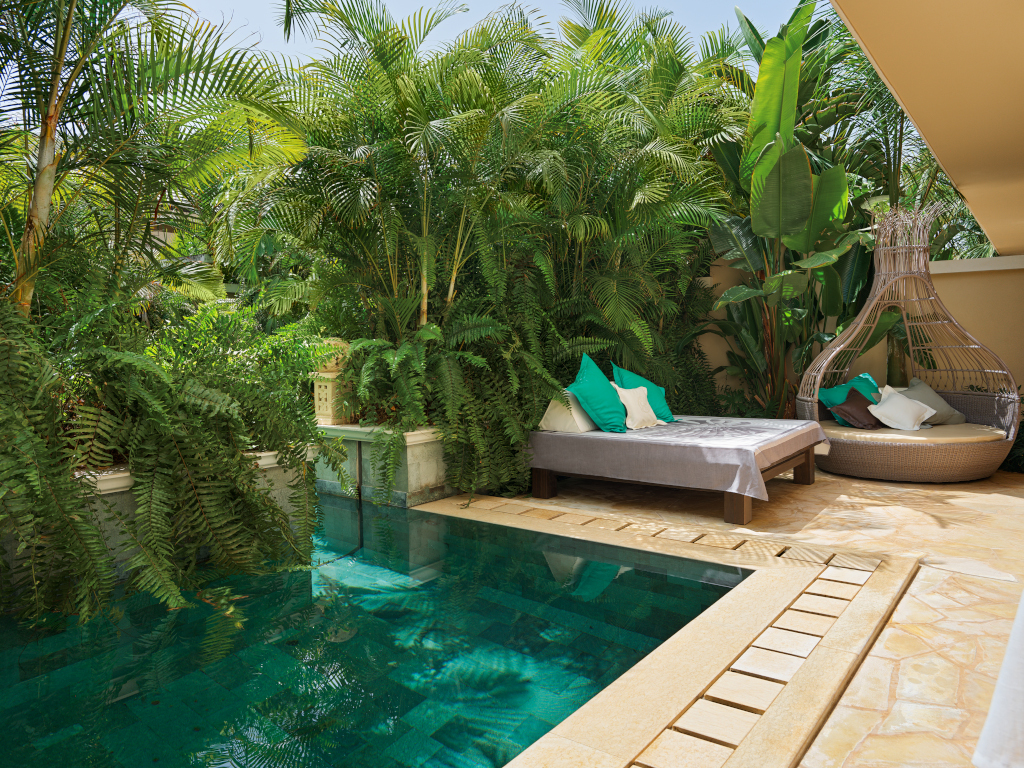 Zwembad omringd door groen en ligstoelen op Tenerife.
