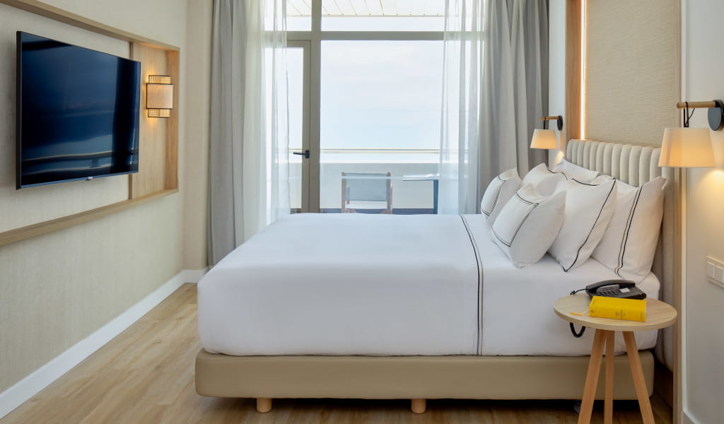 Moderne hotelkamer met bed, tv en zeezicht op Tenerife.