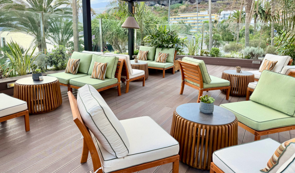 Terras met houten meubels en groene kussens op Tenerife.