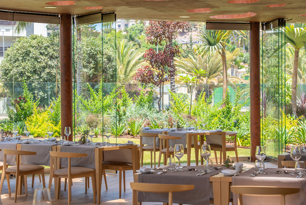 Restaurant met panoramische ramen en uitzicht op een tuin op Tenerife.