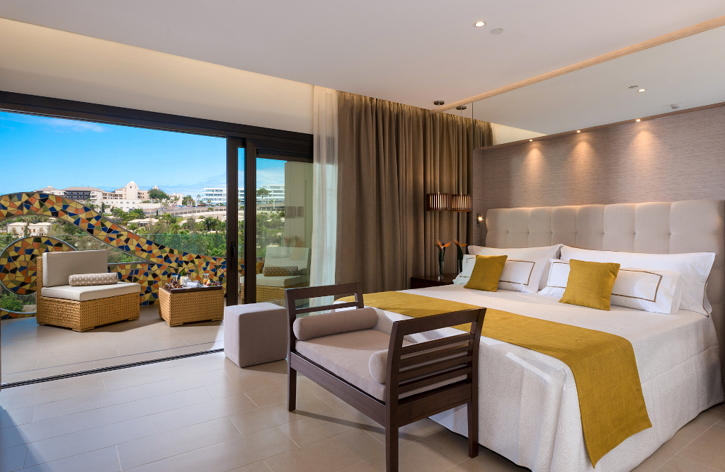 Hotelkamer met tweepersoonsbed en terras met uitzicht op Tenerife.