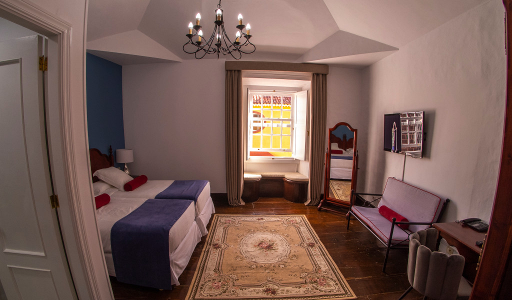 Kamer met tweepersoonsbed, spiegel en raam in een typisch huis in La Laguna, Tenerife.