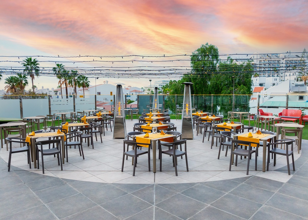 Buitenterras met tafels en stoelen bij zonsondergang op Tenerife.