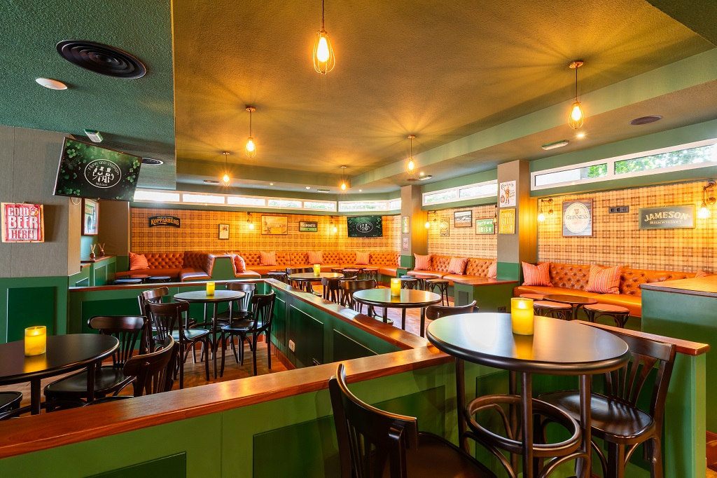 Gezellige bar met ronde tafels, hoge stoelen en decoratieve posters op Tenerife.