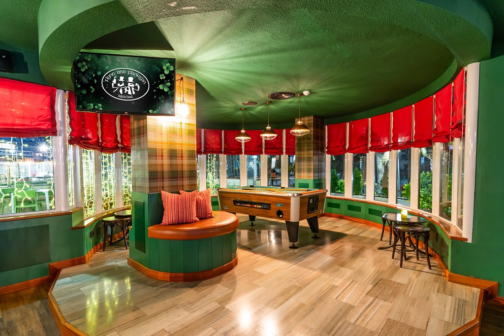 Interieur van een bar op Tenerife met pooltafel en groene en rode decoratie.
